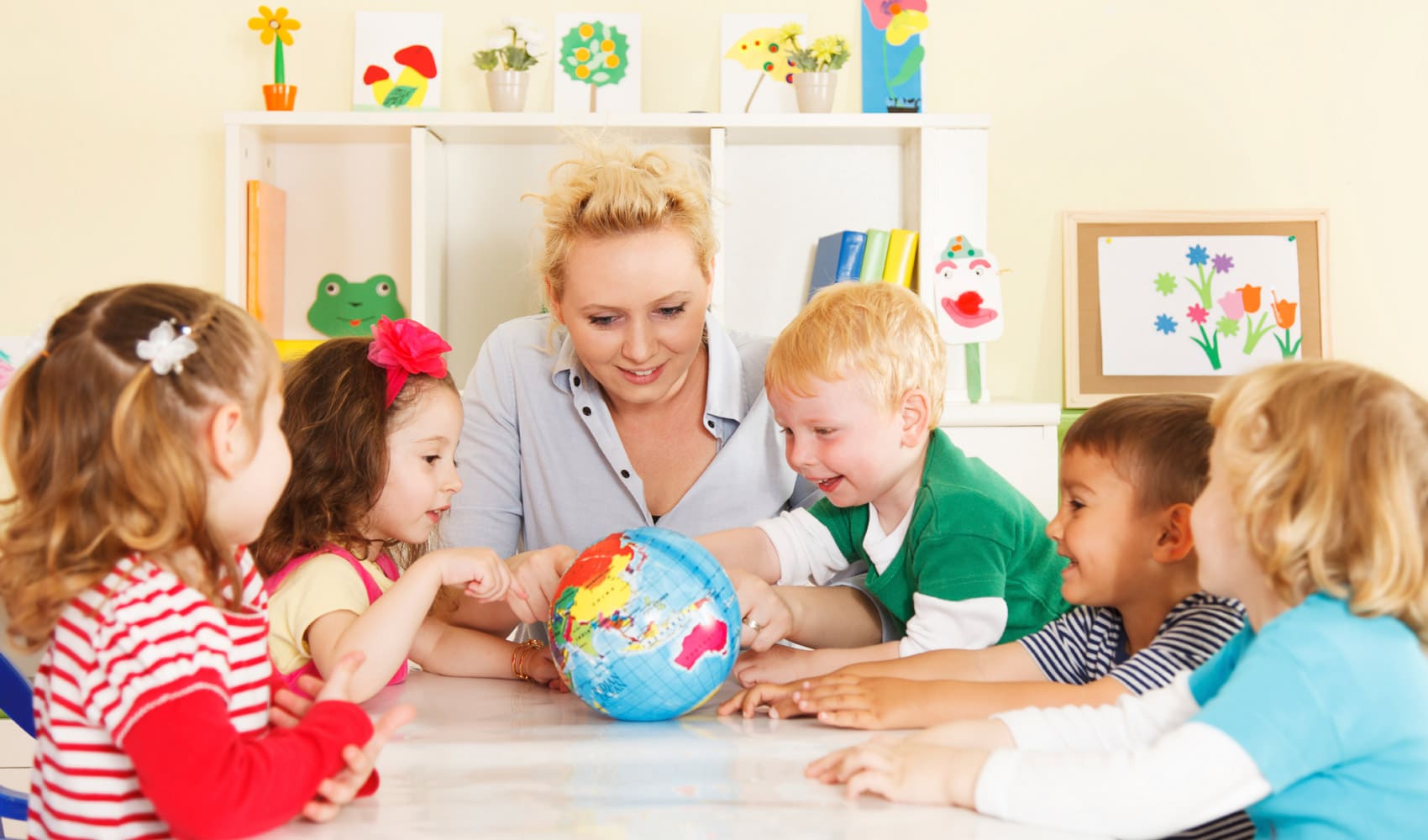Child choosing books with a mentor nearby.
